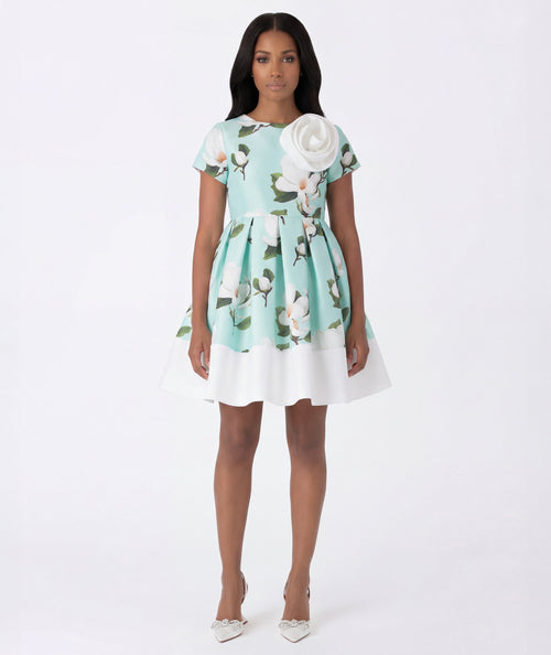 Woman wearing a floral dress with a white flower detail on a white background