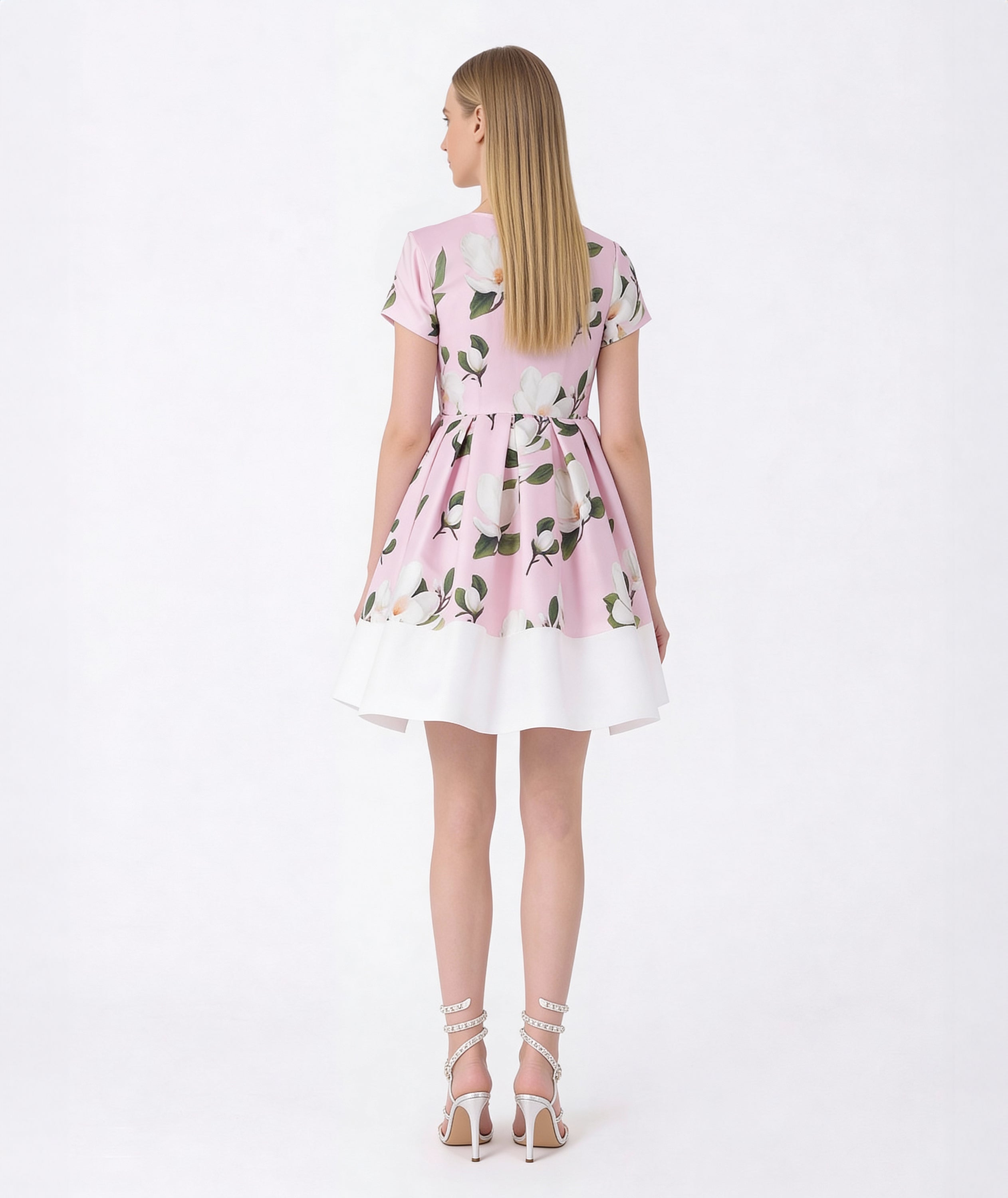 Woman wearing a pink floral dress on a white background