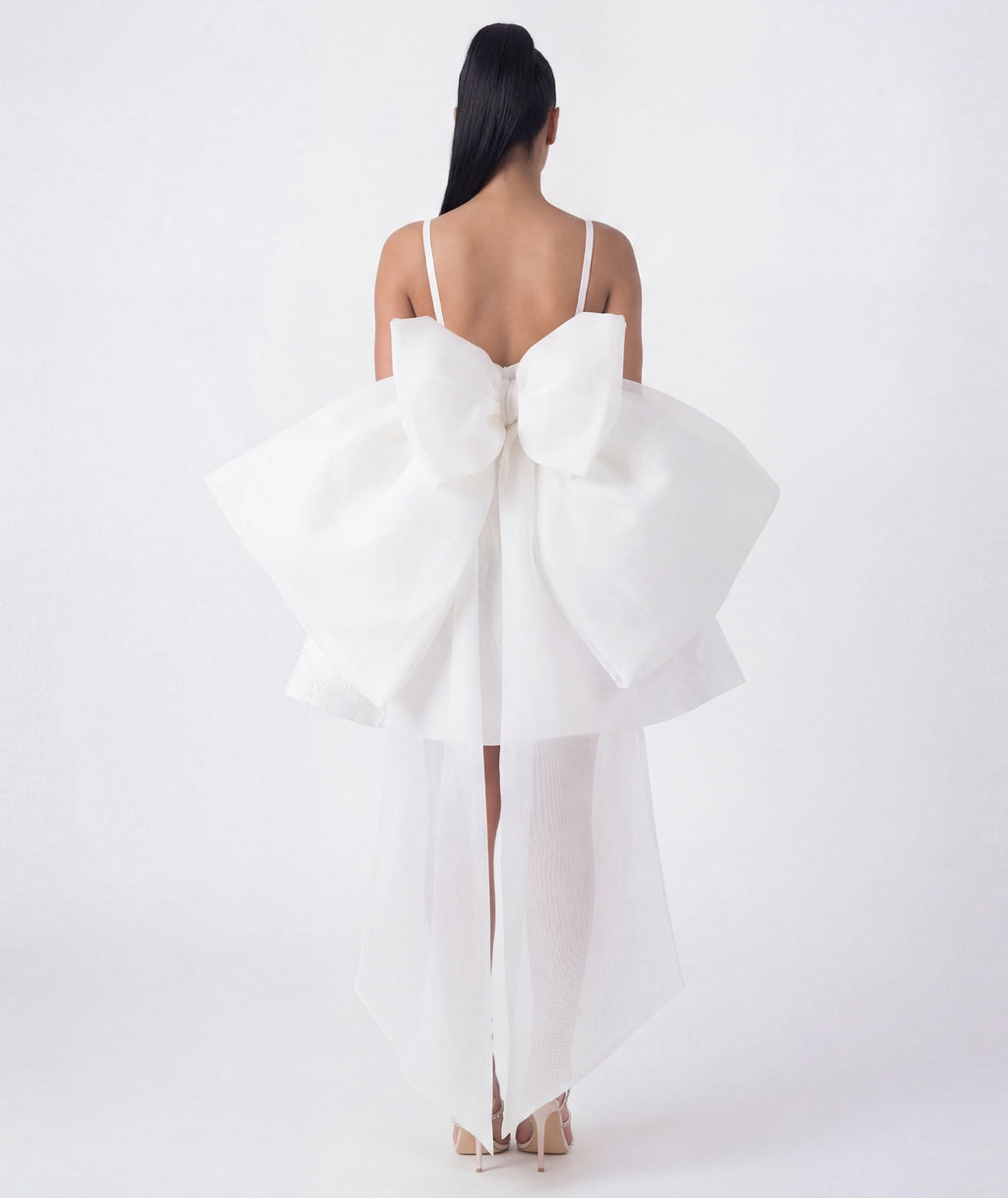 White dress with a large bow detail on a white background