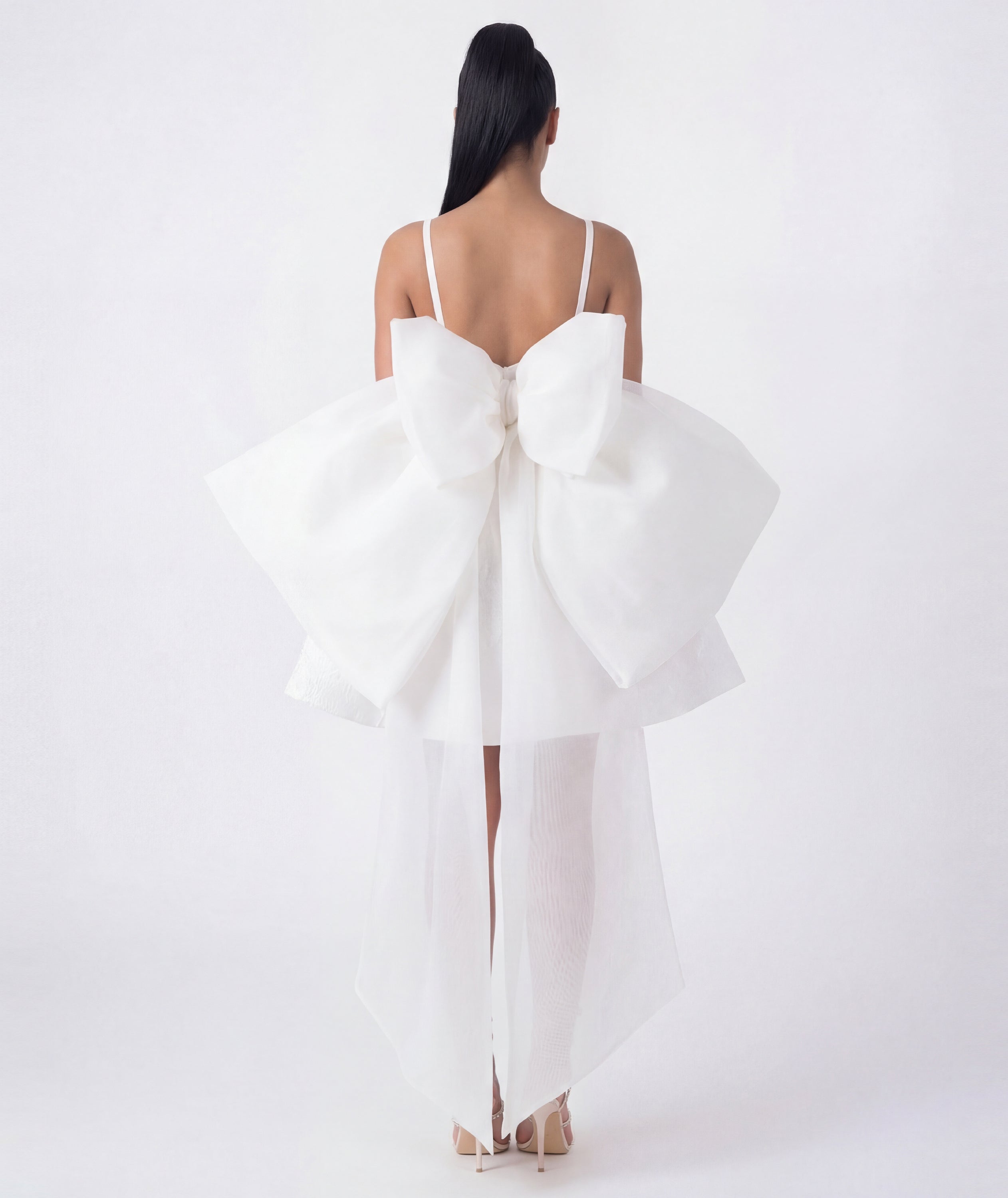 White dress with a large bow detail on a white background