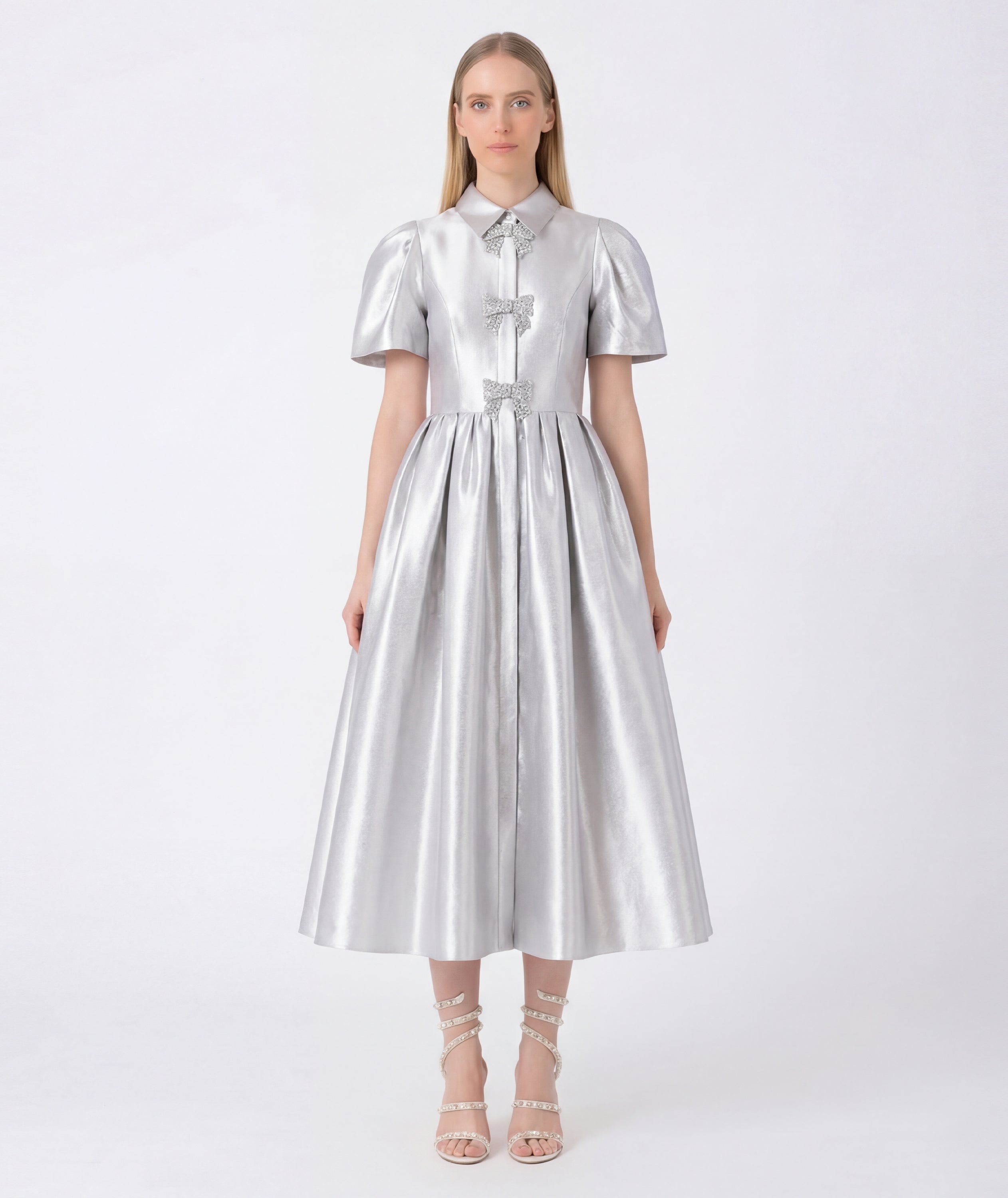 Woman wearing a silver metallic dress on a white background