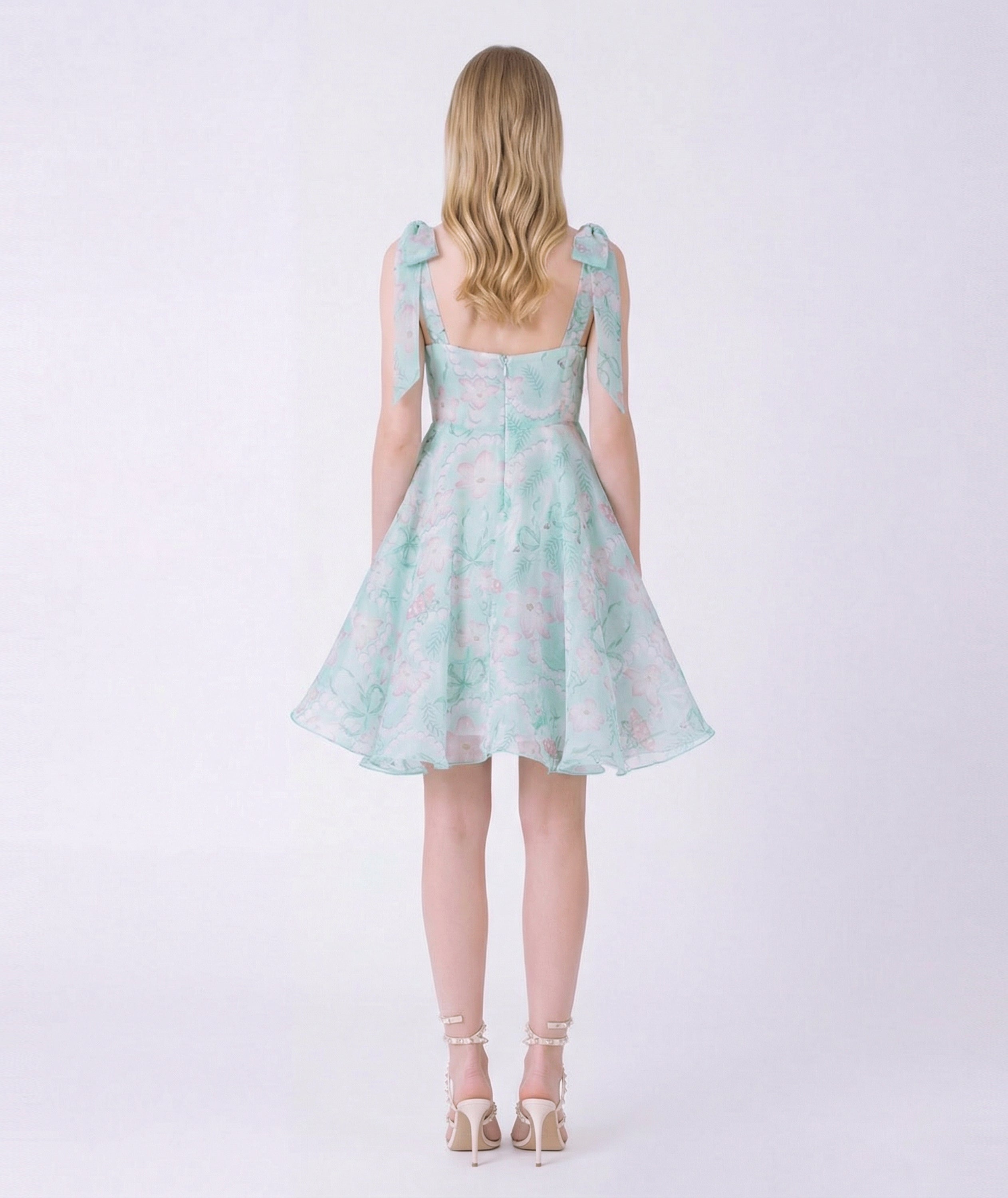 Woman wearing a light blue floral dress on a white background