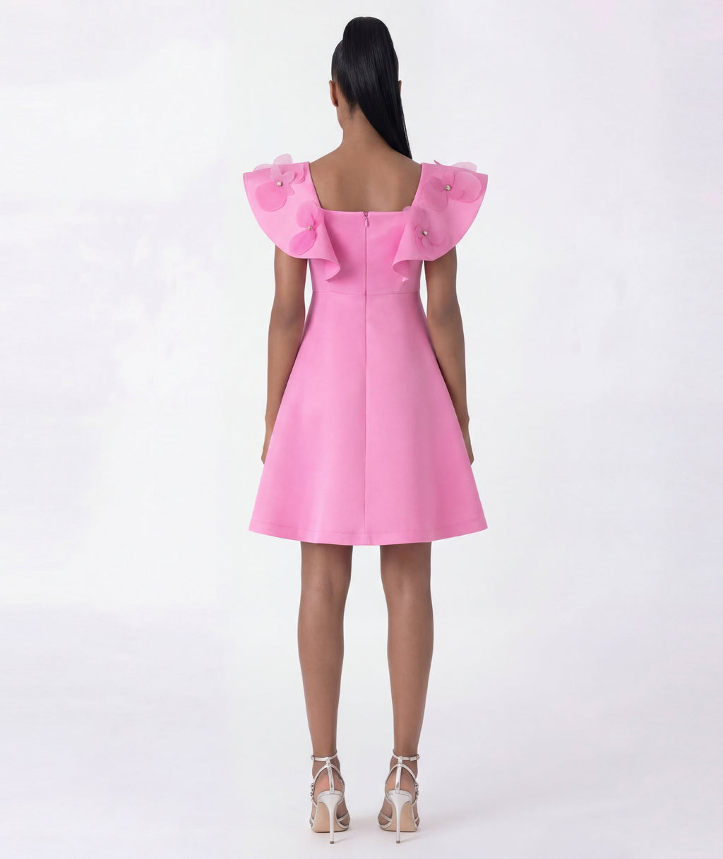 Pink dress with ruffled shoulders on a white background