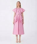 Woman wearing a pink dress with ruffled sleeves on a white background
