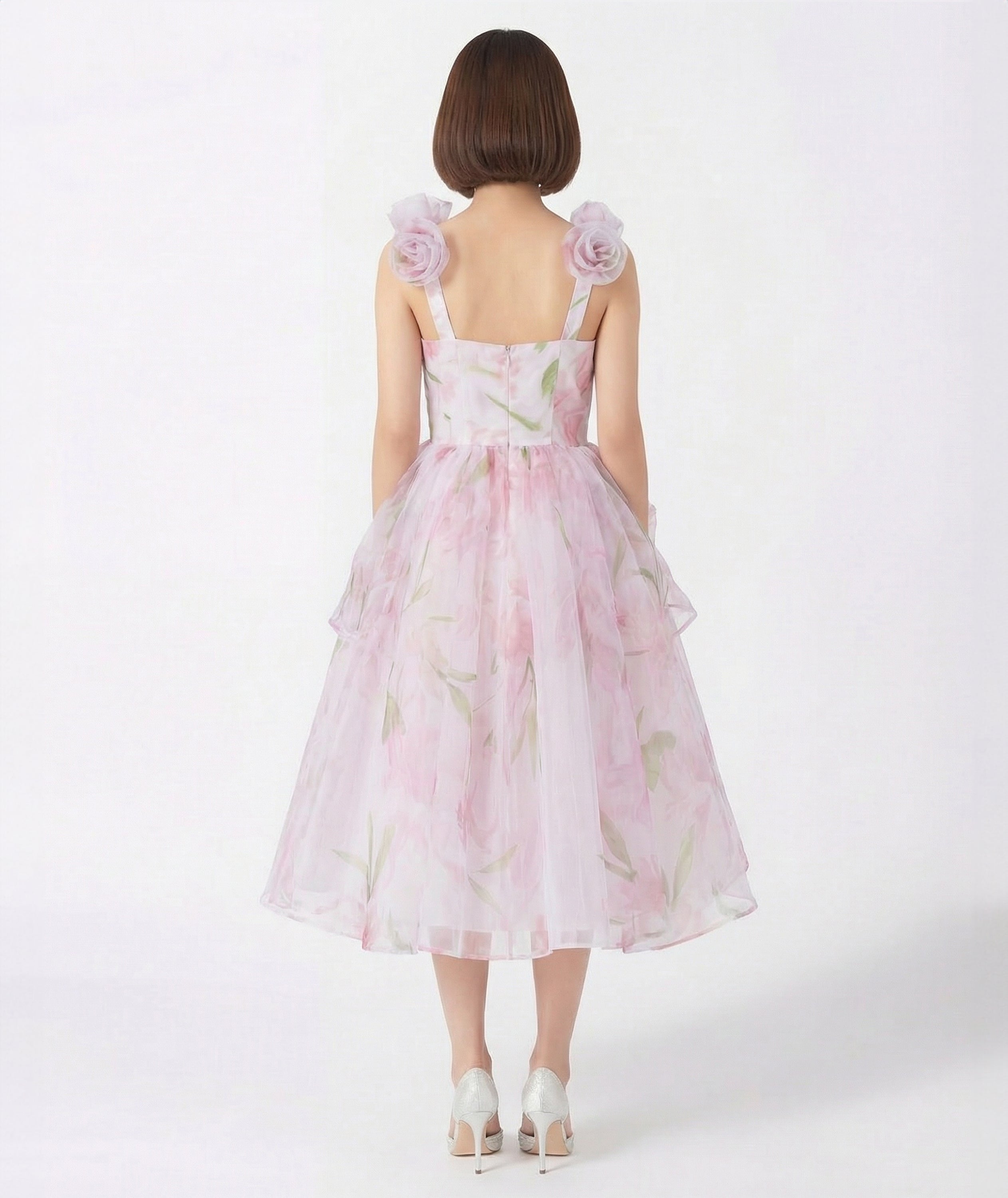 Woman wearing a pink floral dress on a white background