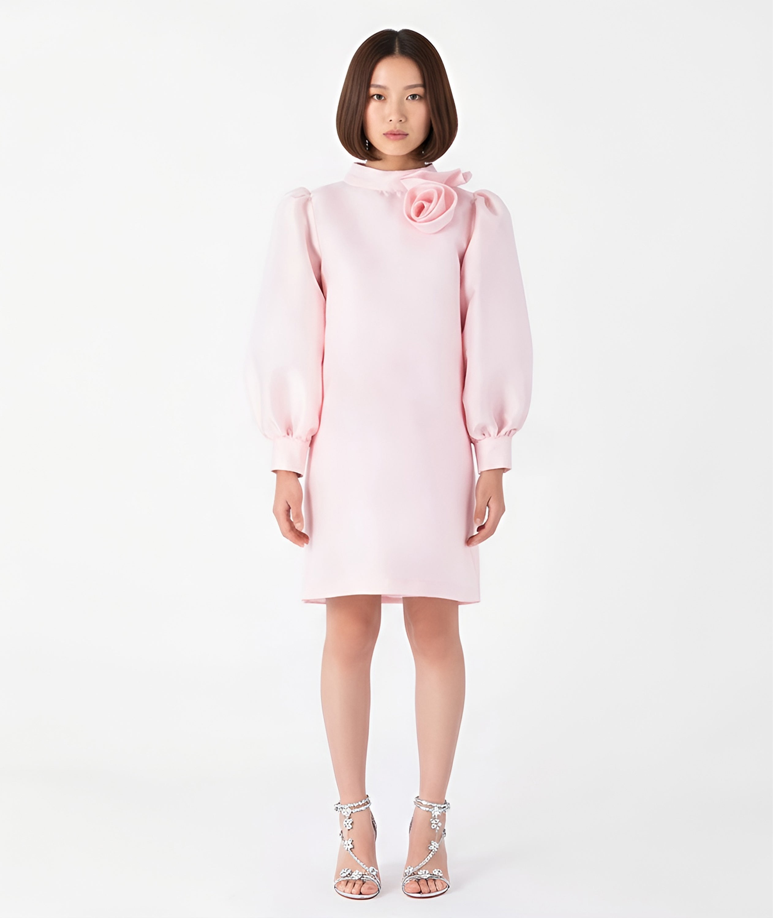 Front view of Mama Luma’s blush pink women’s dress featuring a sculptural rose neckline and voluminous long sleeves. Designed for Mommy & Me matching looks, this elegant satin piece is ideal for Christmas parties, family gatherings, and winter celebrations. Available in sizes XS–XL.