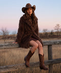 Textured Faux Fur Women's Coat in mocha styled in a ranch setting, featuring plush long-pile texture and a self-tie belt by Mama Luma.